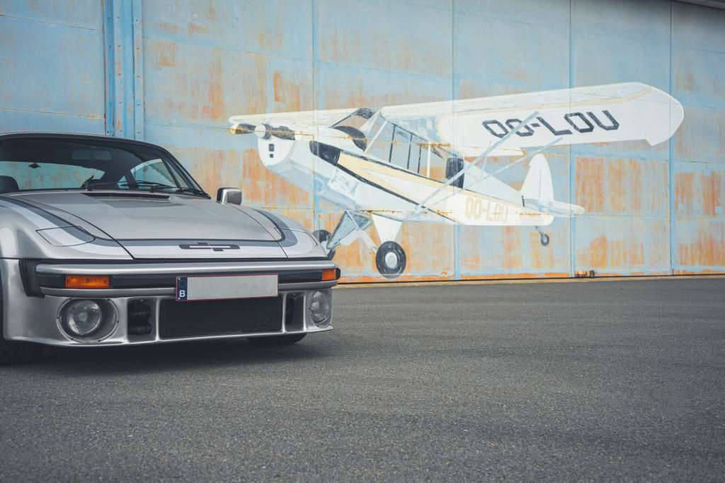 dp motorsport Porsche 911 Turbo Slantnose in front of a shelter with a Cesna painting