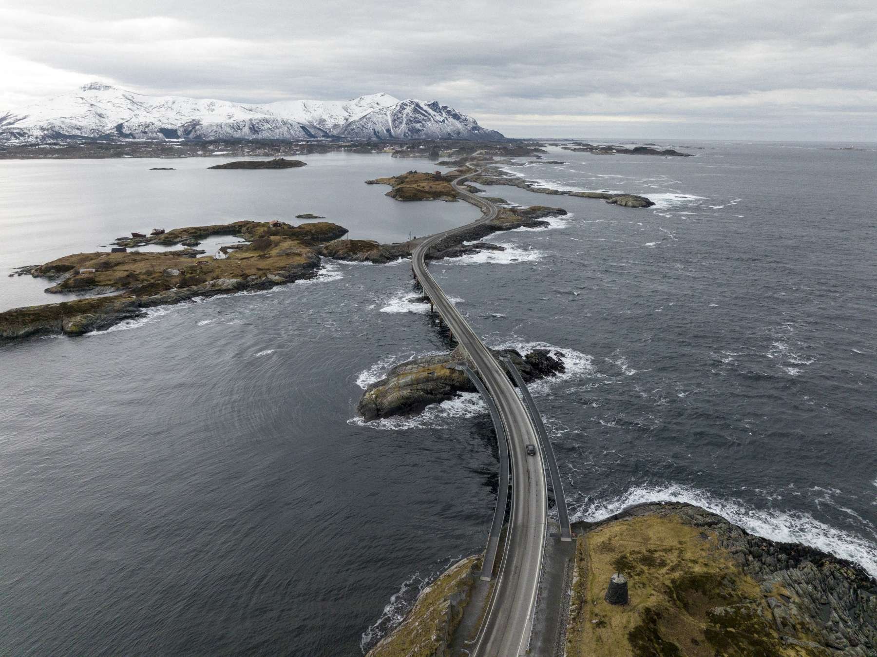 Black Porsche Taycan Cross Turismo driving across Bridge in Norwegian Fjords