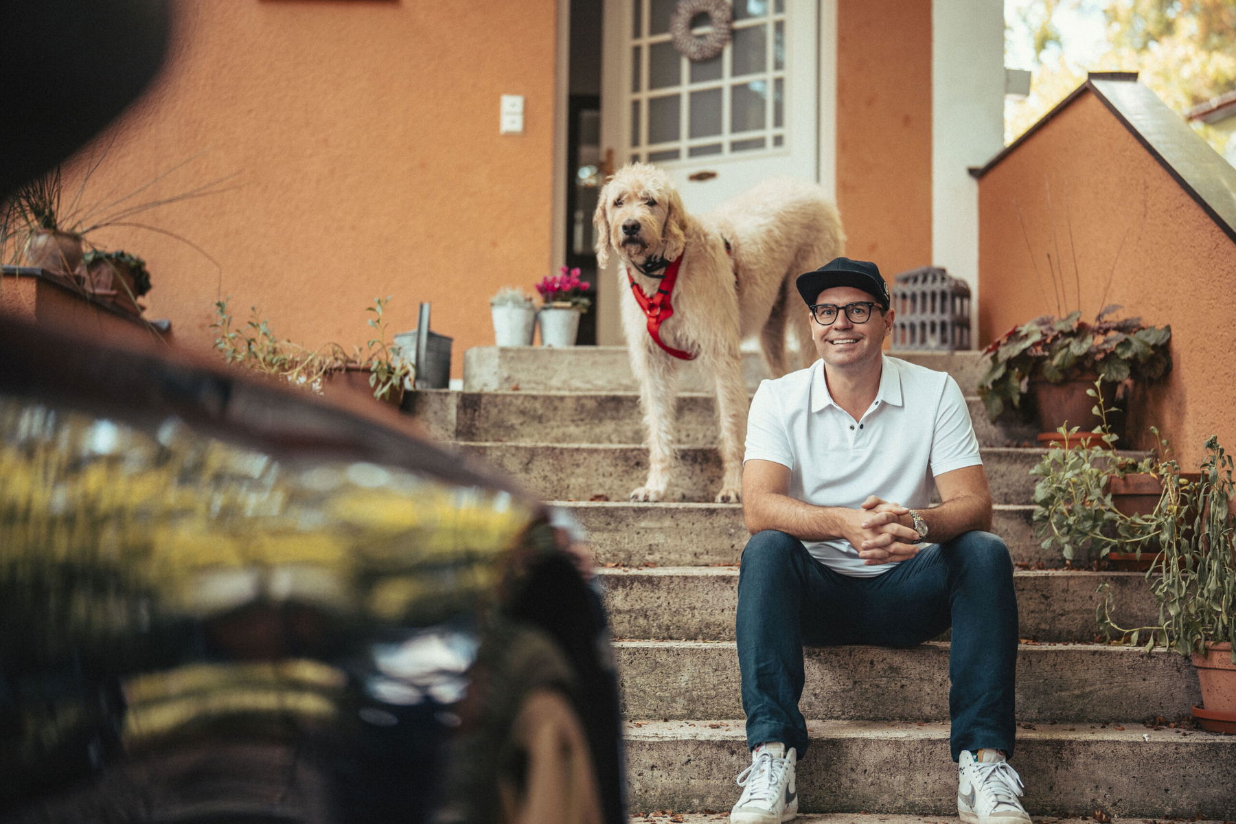 Dr. Manuel Köhne mit Hund vor seinem Porsche 992 Targa