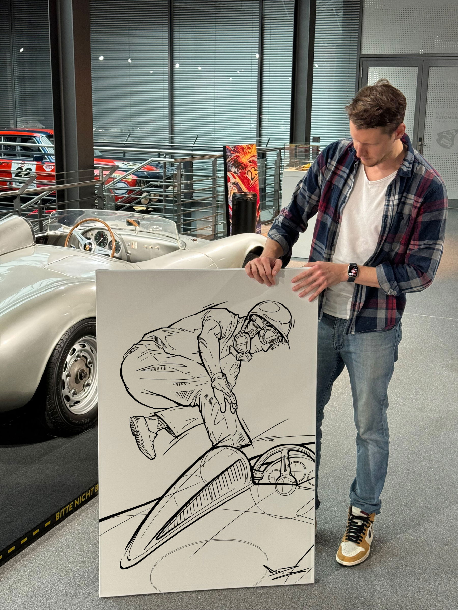 Marco Giuliano mit Line-Art-Bild "Le Mans Start" neben Porsche 550 Spyder