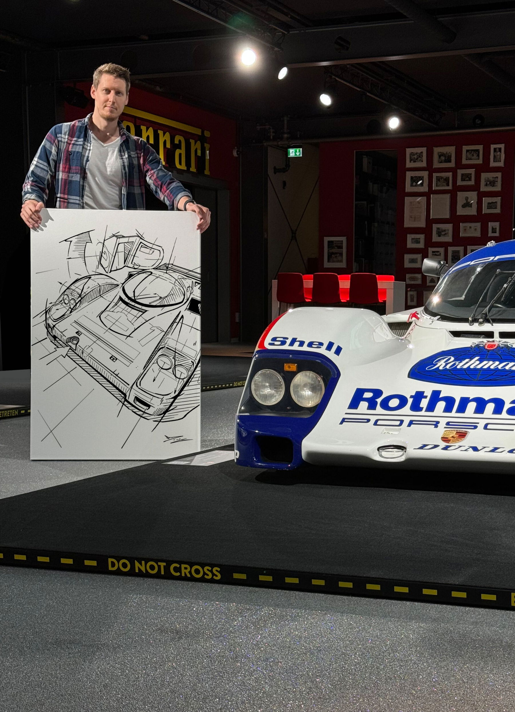 Marco Deusing mit Line-Art-Bild vom Porsche 962 neben Rothmans Porsche 962
