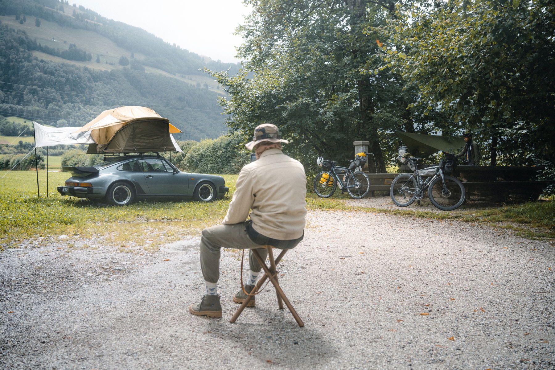 Anthony Richelot sitting in front of his Porsche 911 SC with its rooftent put up