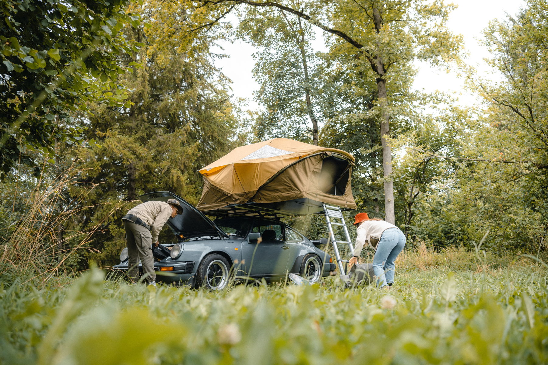 Anthony Richelot putting up his Porsche 911 SC rooftent with his wife
