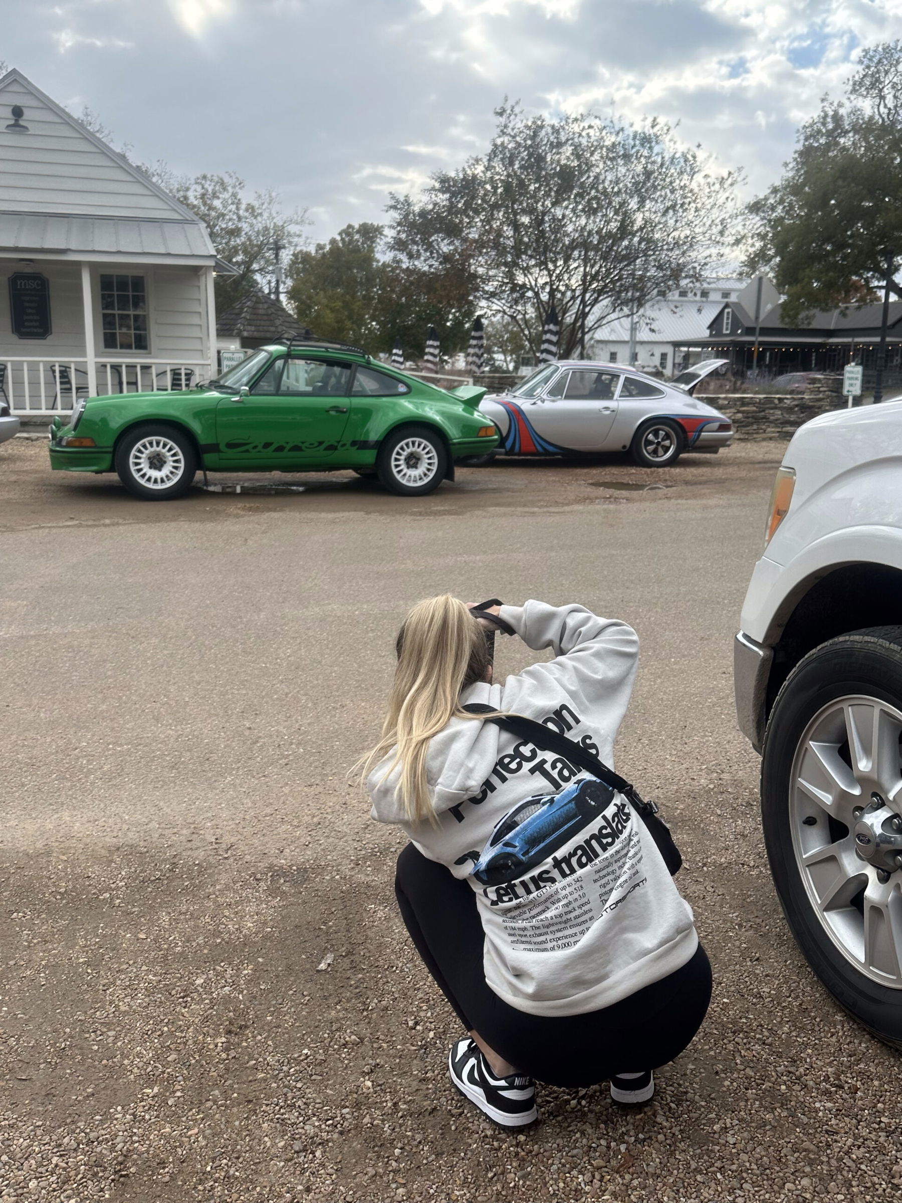 Kaitlyn Clink taking photos of two Porsche 911s